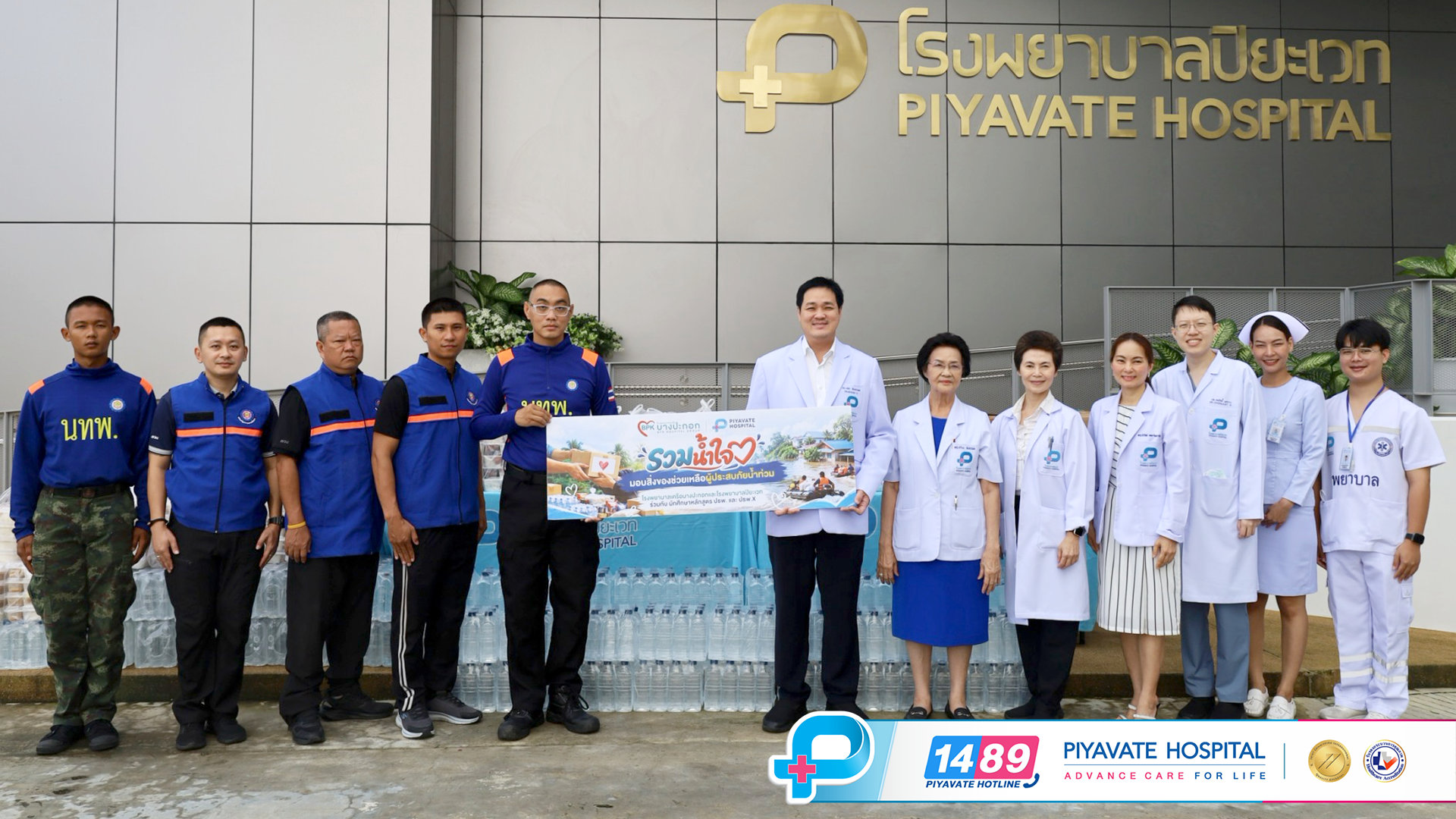 คณะผู้บริหารและบุคลากรทางการแพทย์โรงพยาบาลเครือบางปะกอก-ปิยะเวทถือป้ายช่วยเหลือร่วมกับอาสาสมัคร
