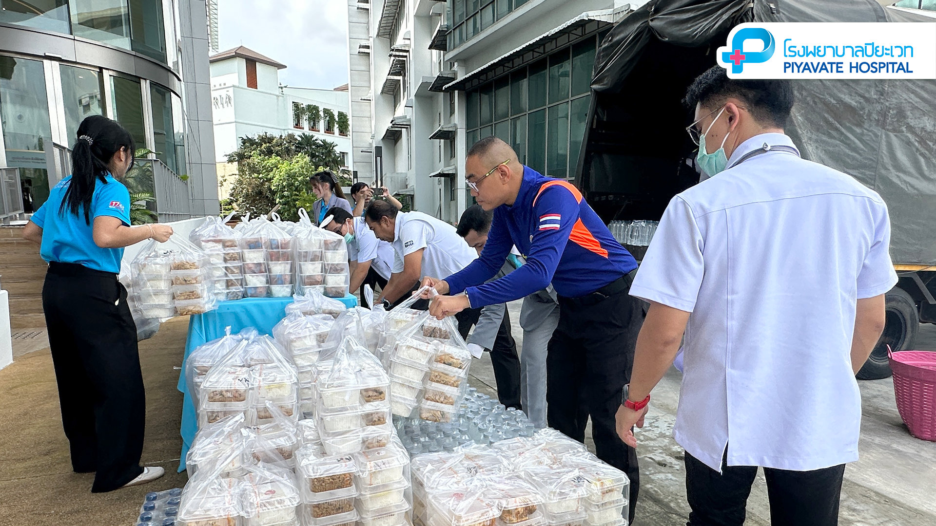 อาสาสมัครจัดเตรียมกล่องอาหารและขวดน้ำบนโต๊ะสำหรับผู้ประสบภัยน้ำท่วม